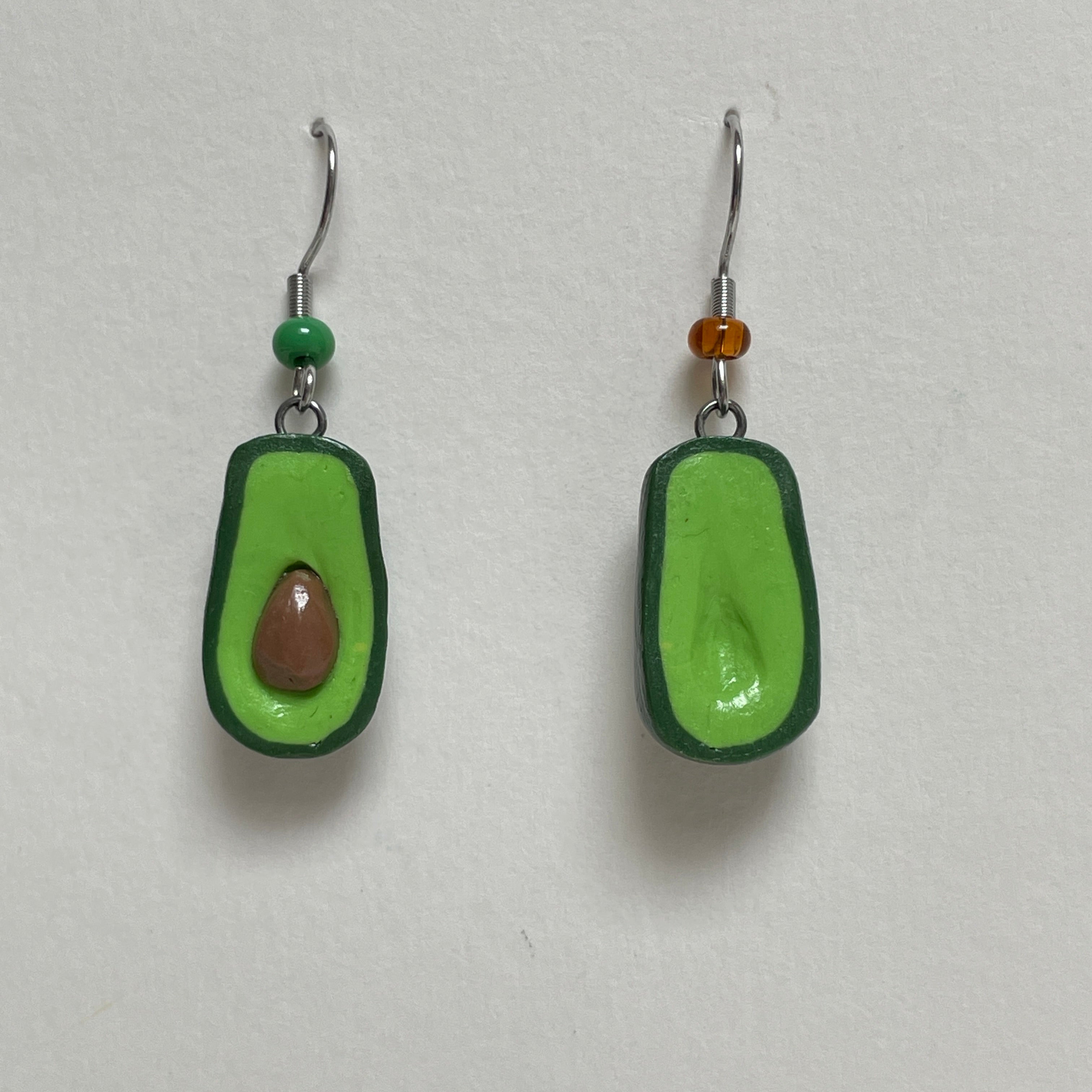 Avocado-shaped earrings on a light gray background
